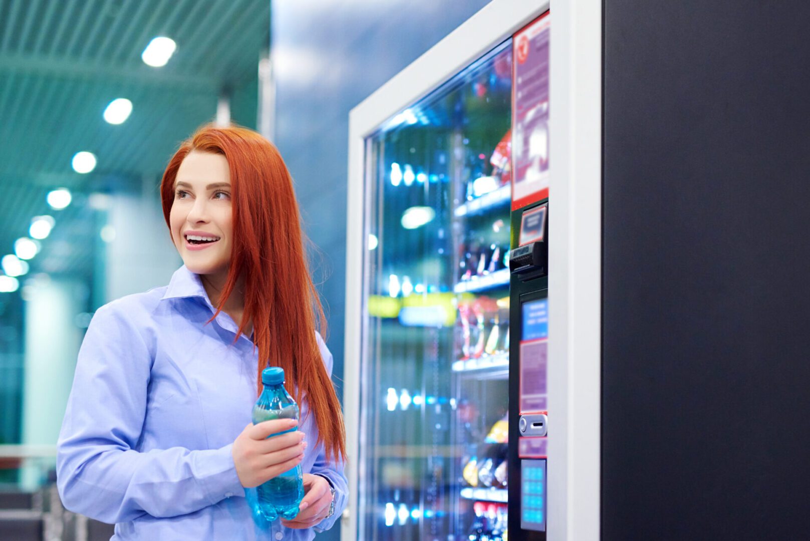 Woman holding water bottle near vending machine